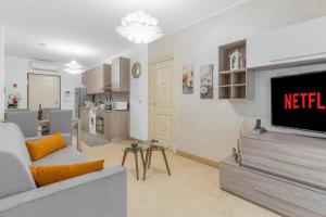 een woonkamer met televisie en een keuken bij Casa Royale al Relais Du Lac in Desenzano del Garda