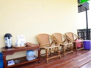 a group of chairs sitting next to a table at Baan Taklom Chomtalay in Ban Sahakham