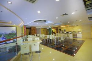 a restaurant with tables and chairs in a room at Chonpines Hotels·Zhongshan Xiaolan LRT Station in Zhongshan