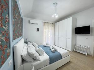 a white bedroom with a large bed with pillows at A Casa di Laura in Ladispoli