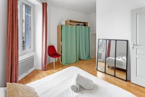 ヴェルトゥにあるLecour - Confortableのベッドルーム1室(鏡、ベッド1台、赤い椅子付)