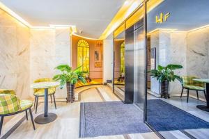 a lobby with a table and chairs and plants at Zmax Hotel·Harbin Bingxue Big World in Harbin