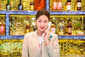 a woman talking on a cell phone in a store at Zmax Hotel·Harbin Bingxue Big World in Harbin