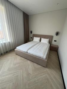 a bedroom with a bed and a wooden floor at Апартаменти Перемоги 1 in Mukacheve