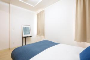 a bedroom with a bed and a picture on the wall at Residence Hotel Liberte in Sapporo
