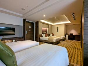 a hotel room with two beds and a television at Hotel Keihan Kyoto Grande in Kyoto