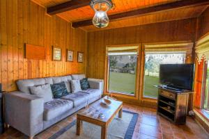 a living room with a couch and a flat screen tv at YourHouse Lar de Lagos in Bueu