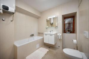 a bathroom with a tub and a toilet and a sink at House Zeljka in Podstrana