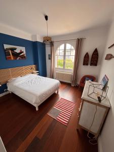 a bedroom with a white bed and a window at Villa face mer - Le Pouliguen in Le Pouliguen