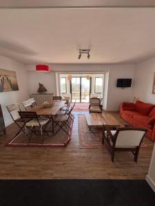 a living room with a table and a red couch at Villa face mer - Le Pouliguen in Le Pouliguen