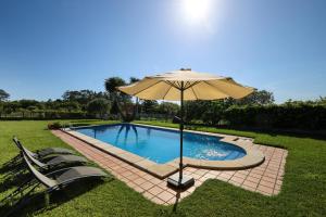 an umbrella sitting next to a swimming pool at YourHouse Lar de Lagos in Bueu