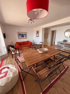 a living room with a wooden table and a red couch at Villa face mer - Le Pouliguen in Le Pouliguen