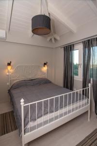 a bedroom with a white bed in a room at ZANTE STARLET - Chic Hideaway with Pool & Comfort in Lagópodhon