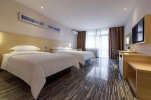 a hotel room with two beds and a television at City Comfort Inn Hotel Guiyang Normal University Yangmingci Metro Station in Guiyang +240 photos