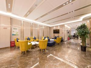 a lobby with yellow chairs and tables in a room at ZMAX Hotel Beijing Tongzhou Universal Tourist Resort Linheli Metro Station in Liyuanzhen