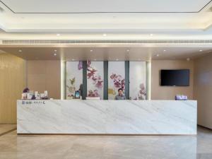 a large marble counter in a lobby with a tv at Lavande Hotels Xuzhou Yunlong Wanda Medical University in Xuzhou