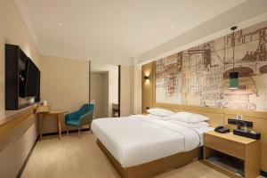 a hotel room with a large bed and a tv at City Comfort Inn Enshi Jingang Baijia Plaza in Enshi
