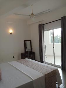 a bedroom with a bed and a large window at Riverside Bliss in Kandy