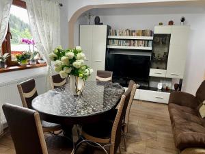 a dining room table with a vase of flowers on it at La Nuti in Sinaia