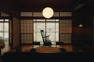 a room with a chair and a table and a lamp at 塩釜バケーションレンタル Sora No Oka in Shiogama