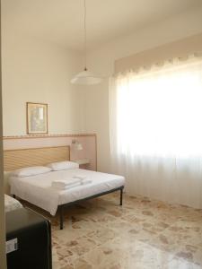 una camera da letto con un letto e una grande finestra di Affitta camere ALMA MATER a Castrignano del Capo