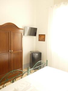 una camera da letto con un letto, un armadio e una stufa di Affitta camere ALMA MATER a Castrignano del Capo