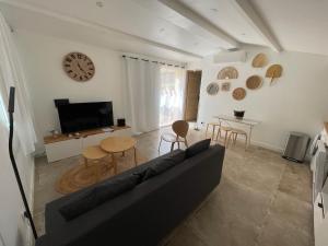 a living room with a couch and a clock on the wall at Maisonnette Aix en Provence in Aix-en-Provence
