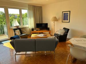 a living room with a couch and chairs and a tv at Haus Potosi, Travemünde in Lübeck