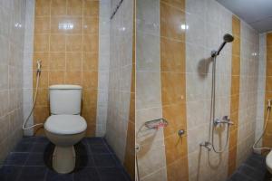 a bathroom with a toilet and a shower at Hotel O Guesthouse 899 in Medan +57 photos