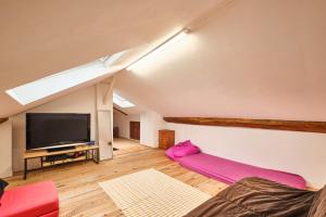 a living room with a flat screen tv and a couch at Au 81 - Maison De Ville à Louer in Moirans