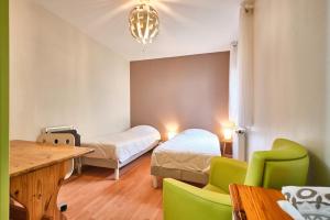 a room with two beds and a table and chairs at Au 81 - Maison De Ville à Louer in Moirans