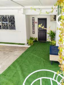 a room with green carpet and a door at D'boss Homestay Sandakan in Sandakan