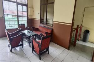 a room with a table and chairs and a couch at Hotel O Penginapan Al-asharNearWarung Acil Ubai in Purbolinggo