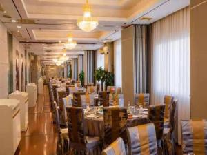 a dining room with a long table and chairs at Kunshan Yuxing Hotel in Kunshan