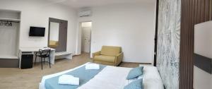 a bedroom with a bed and a desk and a chair at Turrignì Central Rooms in Trapani