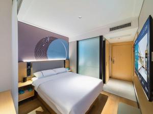 - une chambre avec un grand lit blanc et une télévision à écran plat dans l'établissement City Comfort Inn Wuhan Jianghan Road Jiali Square, à Wuhan