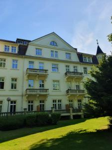 バート・ローテンフェルデにあるFerienwohnung am Kurpark mit Balkonの窓と庭のある白い大きな建物