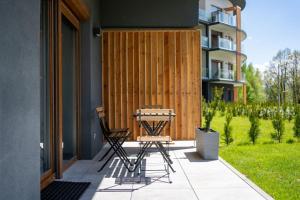 two chairs and a table on a patio at Laguna Beskidów Resort - Apartament A28 Premium in Zarzecze
