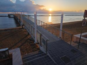 a pier on the beach with the sunset in the background at Casa Mar in Francavilla al Mare
