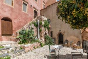 a building with chairs and a table in front of it at Casa tradizionale Goulas in Monemvasia