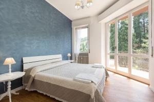 - une chambre avec un grand lit et un mur bleu dans l'établissement Costa Azzurra by Impero House, à Stresa