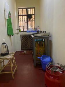 a room with a kitchen with a stove and a window at Magical Fharhana House in Malindi