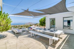Una casa blanca con una mesa de comedor y vista al océano. en Villa Kryvo - Quiet retreat, en Kóstos