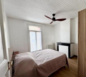 una camera da letto con un letto e un ventilatore a soffitto di Appartement LE BOULOU 2 chambres a Le Boulou
