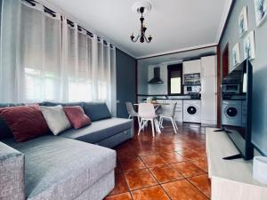 a living room with a couch and a dining room at Apartamentos El Ardinal in Arenas de Cabrales