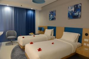 a hotel room with two beds with red flowers on them at Al Khoory Inn Bur Dubai in Dubai