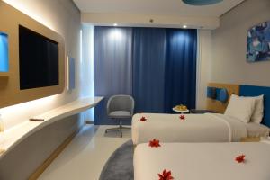 a hotel room with two beds and a tv at Al Khoory Inn Bur Dubai in Dubai