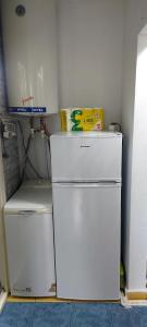 two white refrigerators sitting in a room with a wall at Olimp SeaSun in Olimp