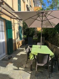 stół i krzesła z parasolem na patio w obiekcie Varazze Apartment w mieście Varazze