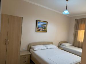 a bedroom with two beds and a picture on the wall at Sunny beach Jonufer in Vlorë
